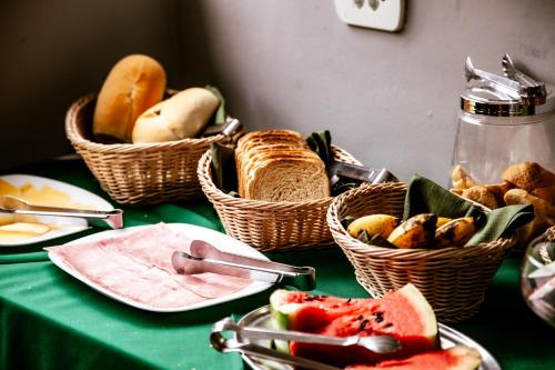 a table with baskets of bread and fruit on it at Hotel Real Paulista in Sao Paulo