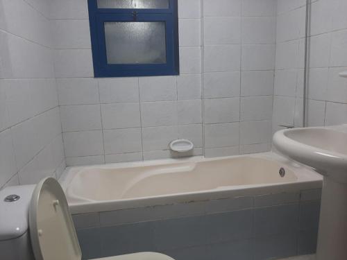 łazienka z wanną, toaletą i umywalką w obiekcie Boys accommodation w Szardży