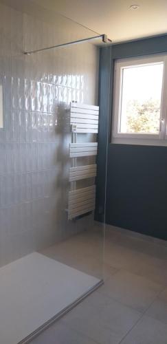 uma cabina de duche em vidro numa casa de banho com uma janela em Vue exceptionnelle en front de mer, 8 personnes em Ver-sur-Mer