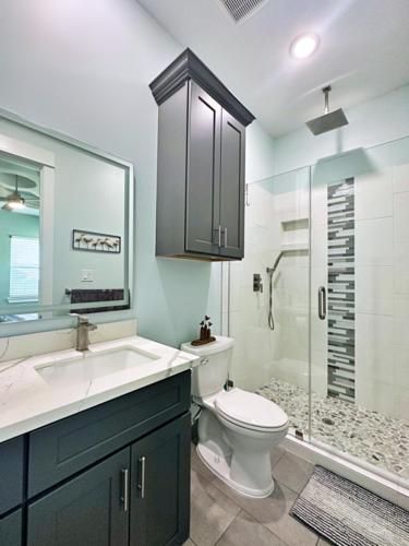 a bathroom with a toilet and a sink and a shower at Beach Please in Surfside Beach