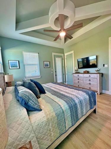a bedroom with a bed and a ceiling fan at Beach Please in Surfside Beach