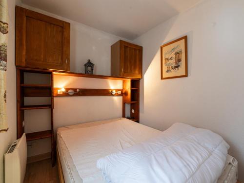 um pequeno quarto com uma cama e armários de madeira em Praz des Esserts - 43 - Appt pied pistes - 6 pers em Morillon