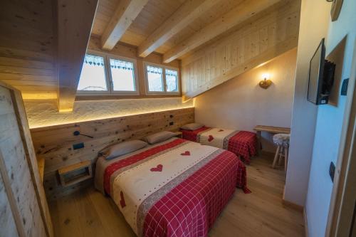 een slaapkamer met 2 bedden in een houten huis bij Appartamenti da Costantino in Padola