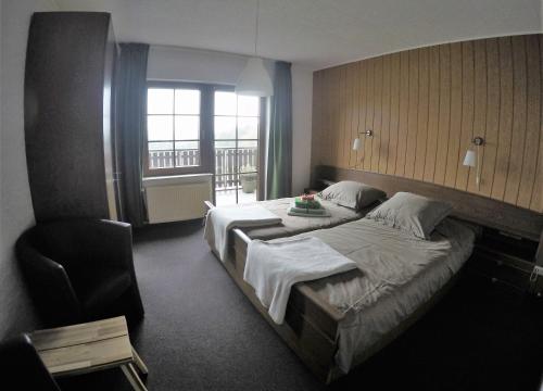 a hotel room with two beds and a chair at Haus Nirgendwo in Lützkampen