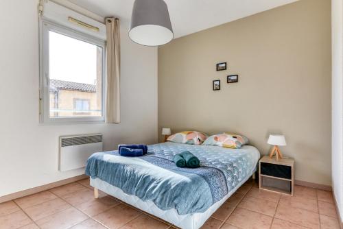 ein Schlafzimmer mit einem Bett und einem großen Fenster in der Unterkunft L'écrin Jardin des Remparts - Parking Privé - Terrasse in Carcassonne