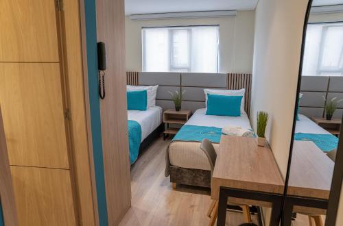 a small room with two beds and a table at Hotel Fontana Bogotá - Corferias in Bogotá
