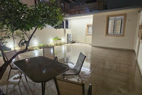 a table and chairs in an empty room with a table and trees at All seasons house in Athens