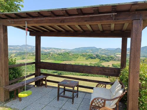 a gazebo with a swing and a bench and a table at appartamento Colticciola Agriturismo Marche in Cagli