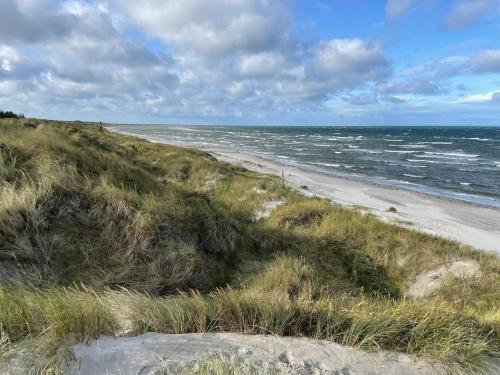 a sandy beach with the ocean in the background at Hotel Strandgaarden in Vesterø Havn