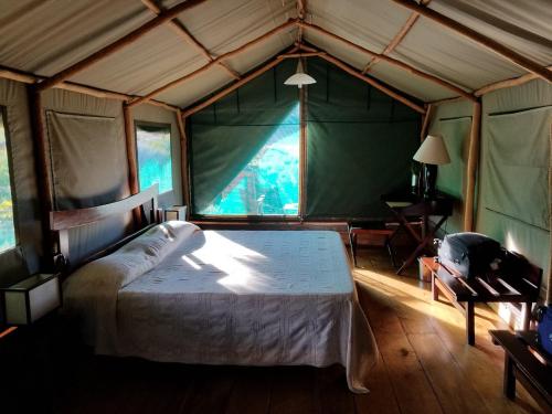 ein Schlafzimmer mit einem großen Bett in einem Zelt in der Unterkunft Satrana Lodge in Ranohira