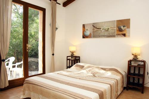 une chambre avec un lit et une grande fenêtre dans l'établissement Villa Tizzano, Santa Giulia, à Porto-Vecchio