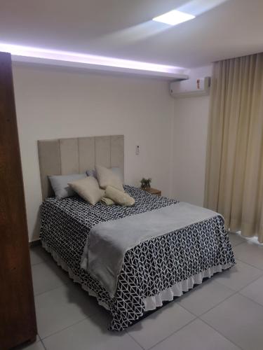 a bedroom with a bed with a black and white blanket at Flat Aeroporto Internacional de GRU 6 in Guarulhos