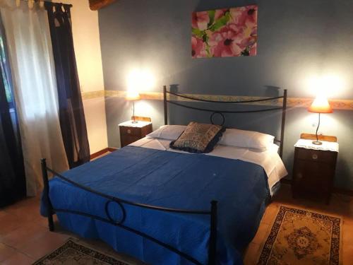 ein Schlafzimmer mit einem blauen Bett und zwei Nachttischen in der Unterkunft I Casali in Calatabiano