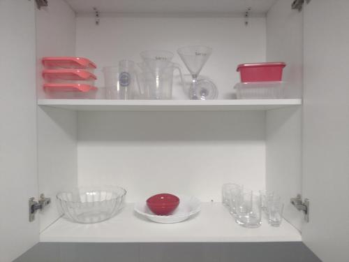 a shelf with bowls and other glass items on it at Flat Aeroporto Internacional de GRU 4 in Guarulhos