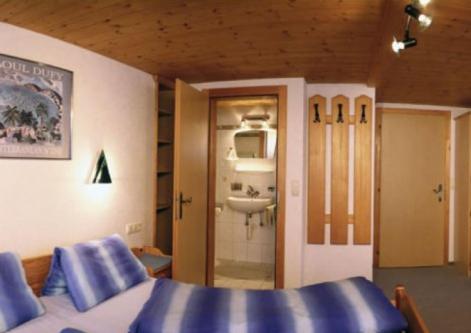 タンハイムにあるFerienhaus Clarissaのベッドルーム(青いベッド1台、シンク付)