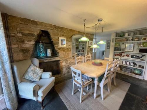 uma sala de jantar com uma mesa de madeira e cadeiras em Sandown 4 bedroom house St Teath em Saint Teath