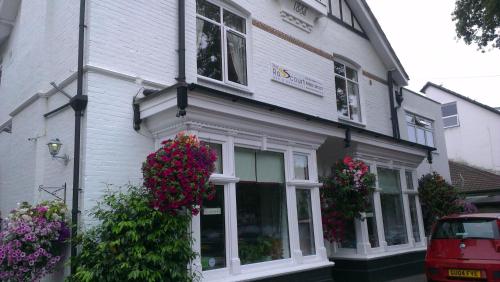 a white building with flowers in front of it at The Rosscourt Hotel in Bournemouth
