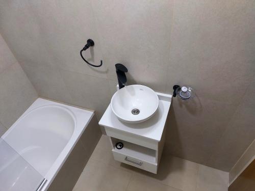 a bathroom with a white sink and a shower at Agua marina in Comodoro Rivadavia
