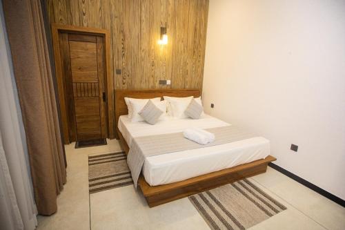 a bedroom with a bed with white sheets and pillows at Ran Villa in Ahangama
