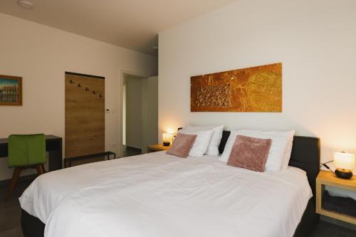 a bedroom with a large white bed with two pillows at Villa Boiky - private pool and amazing sea view, Istria in Materada