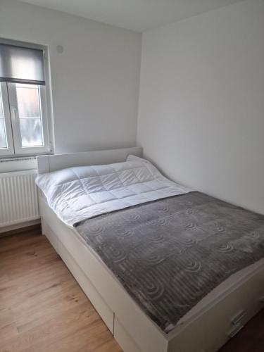 a white bed in a room with a window at Ferienwohnung Tihana in Trossingen