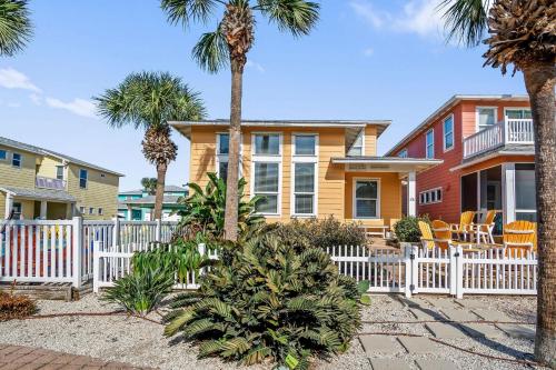 a house with a white fence and palm trees at Friday Life in Port Aransas
