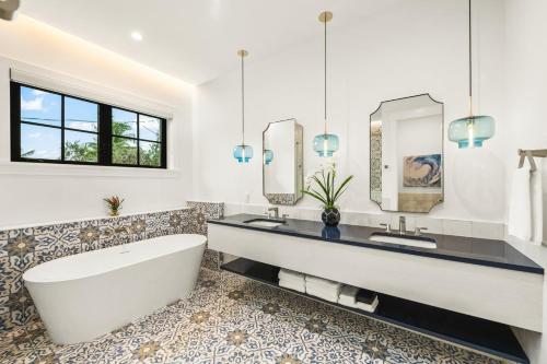 een badkamer met een bad, 2 wastafels en een spiegel bij Salty Oak in Siesta Key