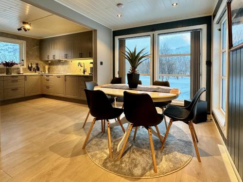 a kitchen and dining room with a table and chairs at Panorama Valley Lofoten in Bøstad