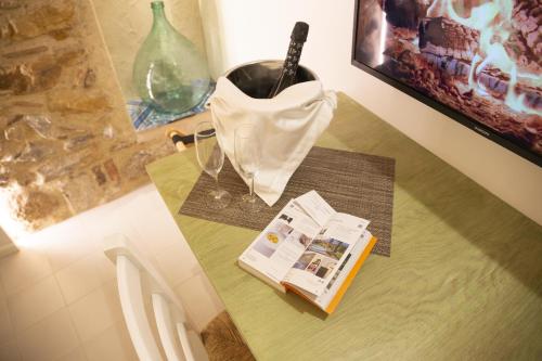 a table with a book and a bag and a wine glass at PORTA SOPRANA luxury guest House & spa in Sclafani