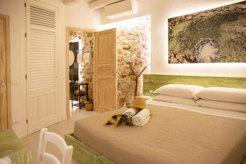 a bedroom with a bed with a painting on the wall at PORTA SOPRANA luxury guest House & spa in Sclafani