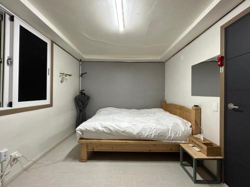 a small bedroom with a bed and a window at 369 Motel in Mokpo