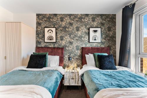 a bedroom with two beds and a wall with wallpaper at Comfy 4-Bed in Bristol - Garden - Sleeps 10 in Bristol