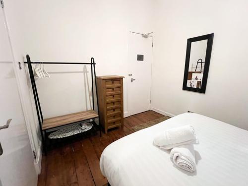 a bedroom with a bed and a dresser and a mirror at Central Edinburgh, Quirky & Modern 1 bed apartment in Edinburgh