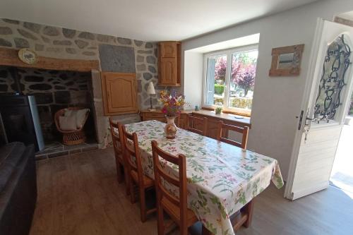 a kitchen with a table and chairs and a fireplace at GITE 6 personnes à Pailherols in Saint-Clément