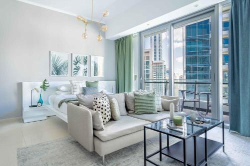 a living room with a couch and a large window at GuestReady - Studio | Balcony-Marina View in Dubai