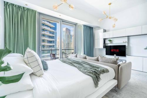 a bedroom with a large bed and a large window at GuestReady - Studio | Balcony-Marina View in Dubai