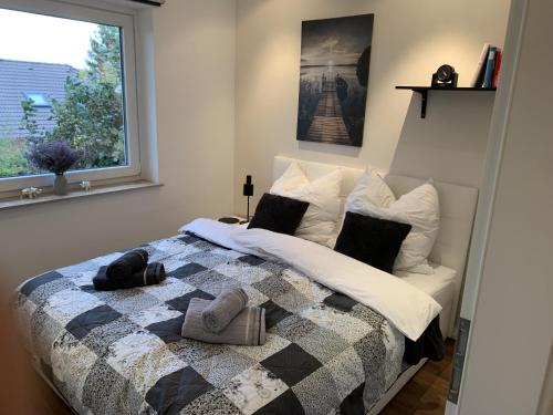 1 dormitorio con 1 cama con manta y ventana en Ferienwohnung Glücksmomente, en Habichtswald