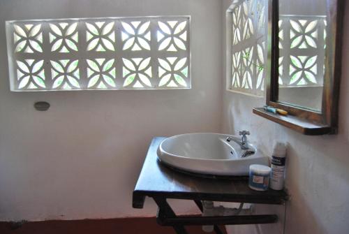 uma casa de banho com um lavatório e um espelho em Beach Bungalow 60sqm Fully serviced in Matemwe Zanzibar em Gazija