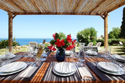 une table avec des assiettes et un vase de fleurs dans l'établissement Villa Son Vives Townhouse by Slow Villas, à Banyalbufar