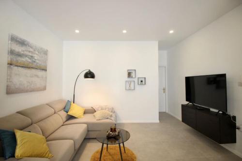 a living room with a couch and a flat screen tv at Gzira 3 bedroom apartment in Il-Gżira