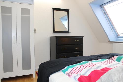 a bedroom with a bed and a dresser and a mirror at Apartments Ålholmvej in Copenhagen
