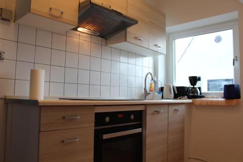 a kitchen with a black stove and a window at Apartments Ålholmvej in Copenhagen