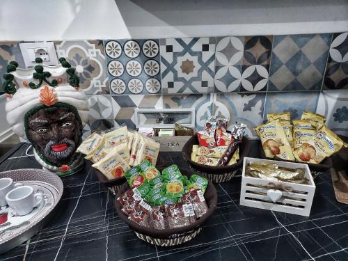 a counter top with a table with snacks and a statue at La Casa del Moro - All' Operà in Palermo