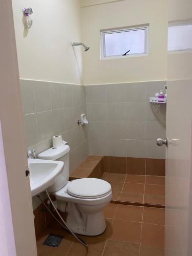 a bathroom with a toilet and a sink at Aurora’s Homestay Sandakan in Sandakan