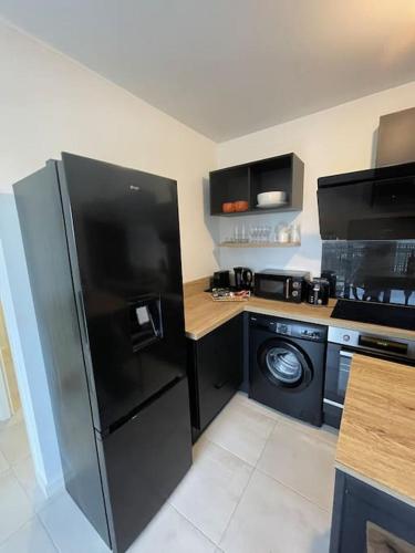 a kitchen with a refrigerator and a washer and dryer at Luxury apartment near CDG & Parc Asterix in Vémars