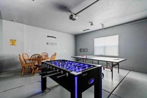 Cette chambre comprend une table de ping-pong et des chaises. dans l'établissement Private Oasis On 2 Acres with Indoor Pool and Theater, à Eagle