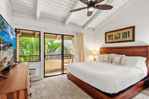 a bedroom with a bed and a flat screen tv at Ekolu 1602 in Wailea