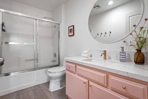a bathroom with a toilet and a sink and a mirror at The Modern Indio Large Family Home With Pool And Spa in Indio