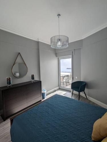 a bedroom with a bed and a mirror and a chair at Bela Vista Solmar 3 B/R in Ponta Delgada