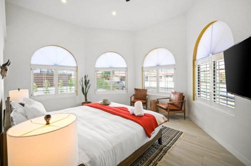 een slaapkamer met een groot bed en een rode deken bij La Reina Inn Swim Club in Bermuda Dunes